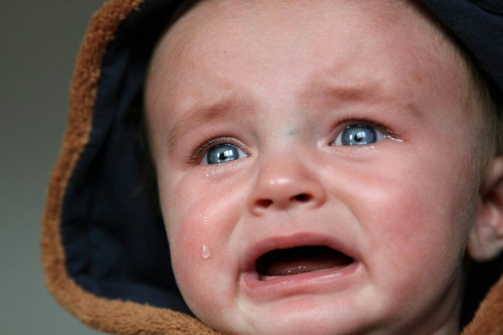 Dreumes van 1 jaar ligt wakker in bed tijdens slaapregressie en weigert dutje.